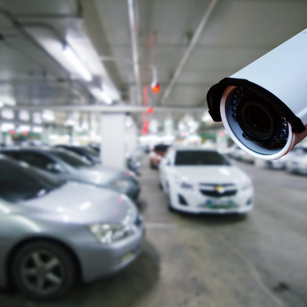 cctv security camera on blurred background of indoor car park, security technology concept.